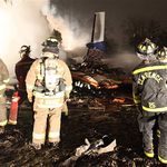 Firefighters fight the blaze from Flight 3407's crash